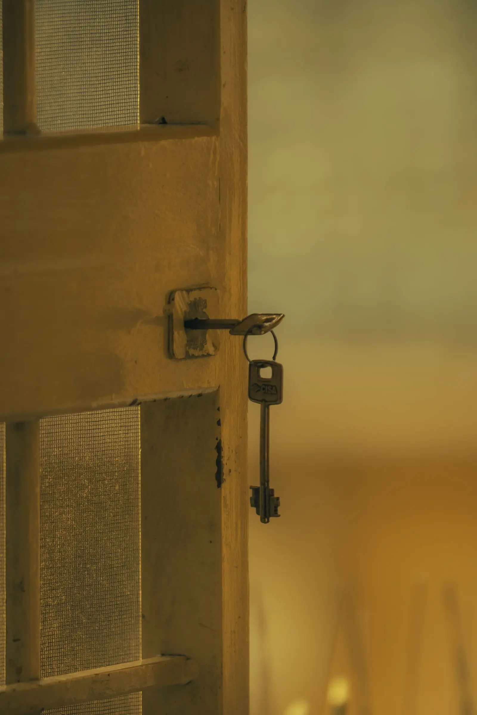 Llave colgando de la cerradura de una puerta de madera